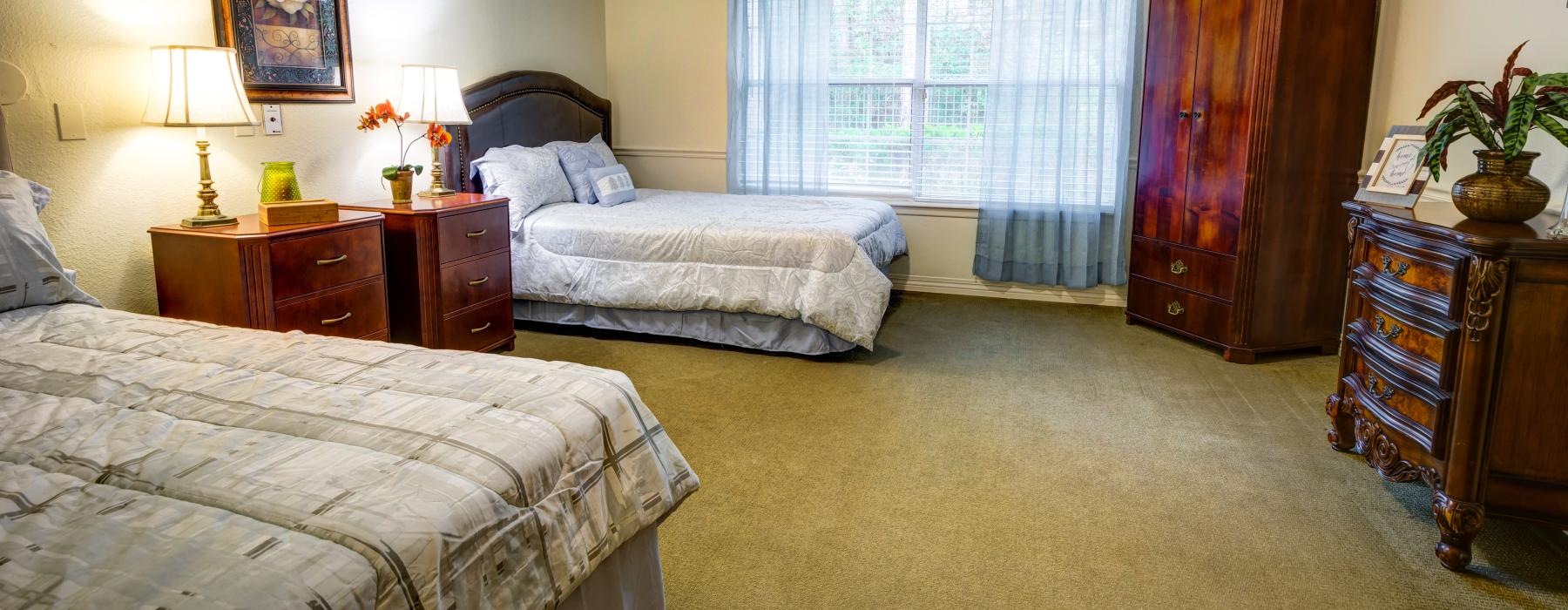 a bedroom with two beds and large windows