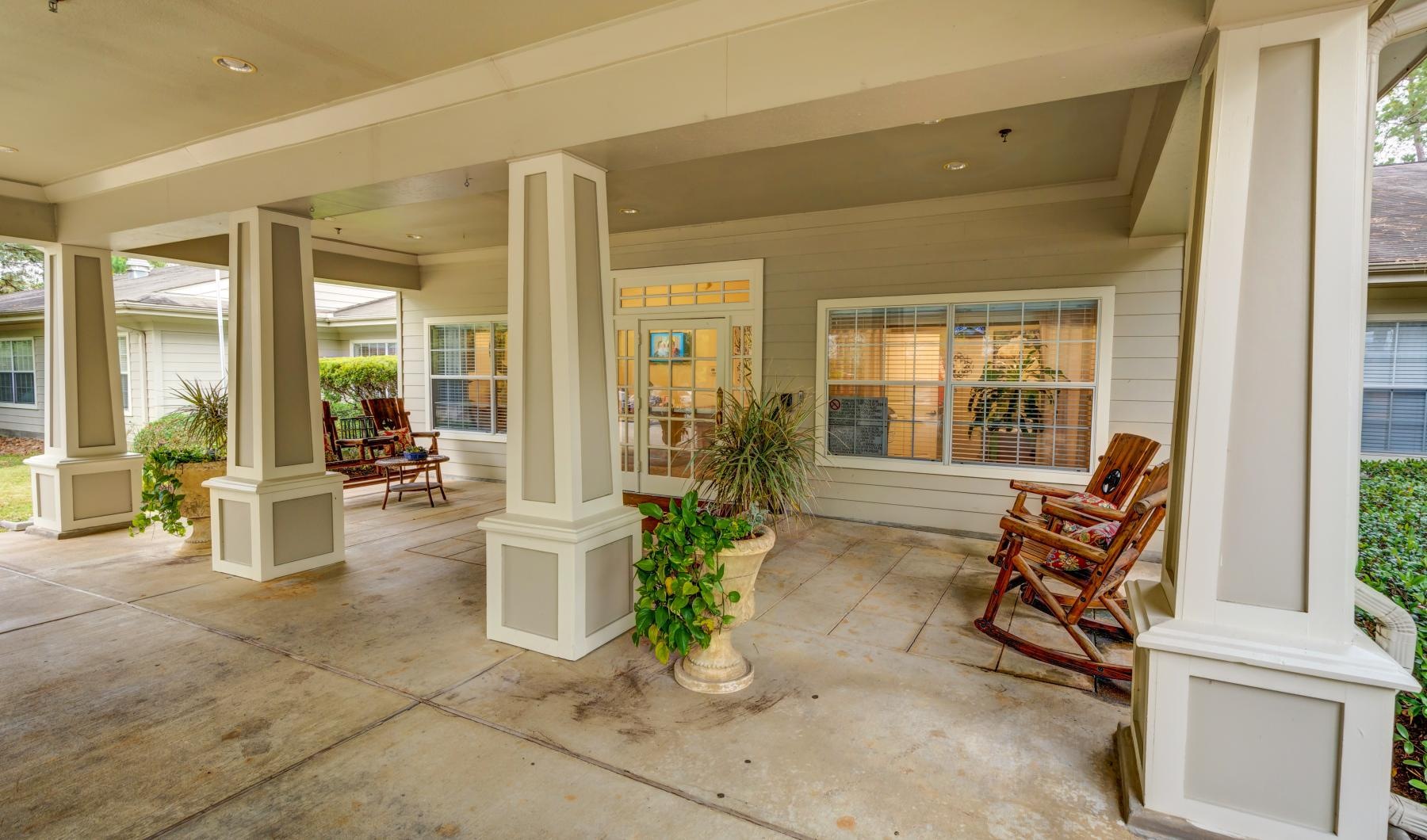 Find your perfect fit at The Auberge at The Woodlands covered porch with rocking chairs outside clubhouse